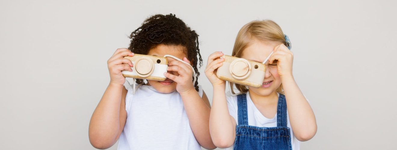 two kids taking photo using a camera